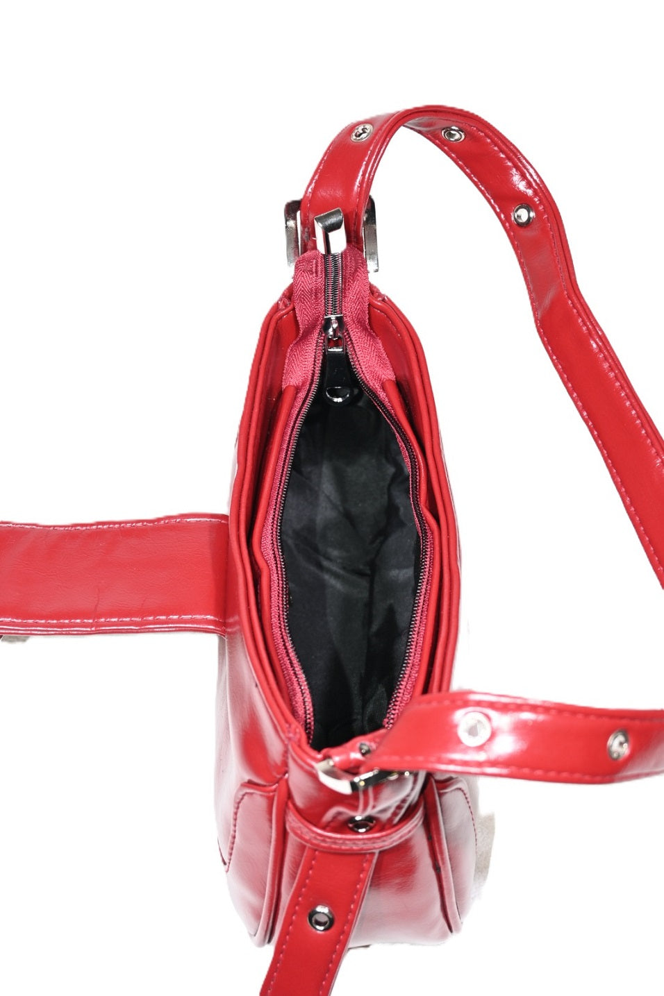 Top view of a red leather handbag with zipper closure and adjustable strap on white background