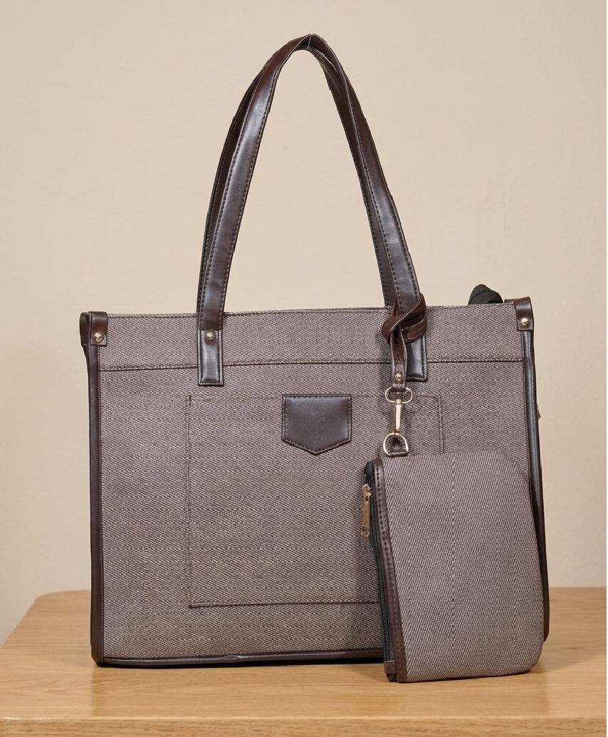 Elegant brown tote handbag with matching pouch on wooden table, premium materials