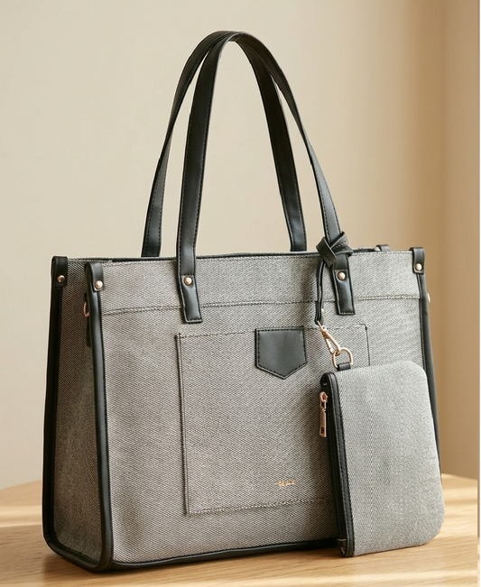 Gray structured handbag with black leather trim and matching wallet on a wooden surface