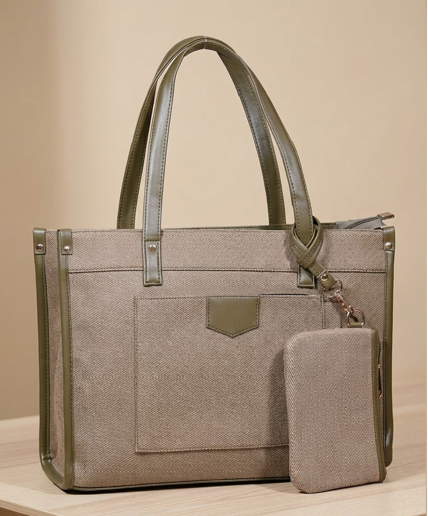 Taupe tote handbag with green leather trim and matching pouch on a wooden surface